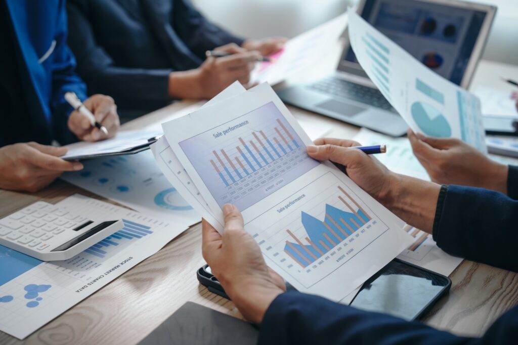 Professional business team meeting in formal suits, working at desks with financial papers
